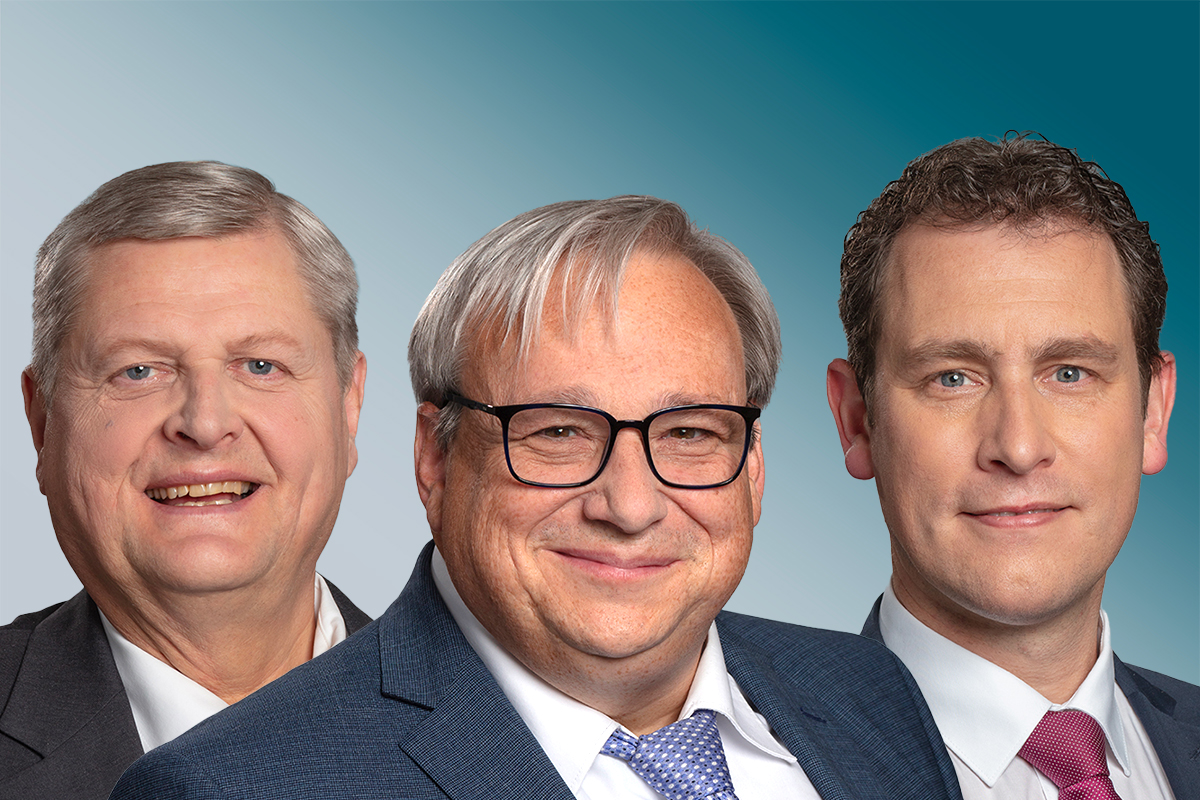 Drei Männer schauen in die Kamera und lächeln.